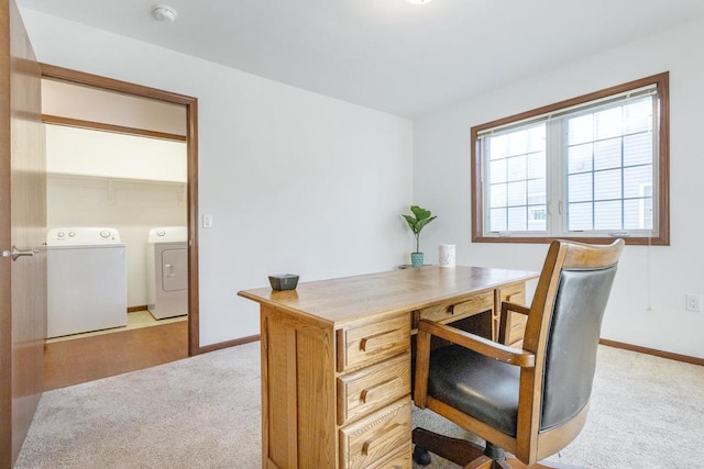 carpeted office featuring washing machine and clothes dryer