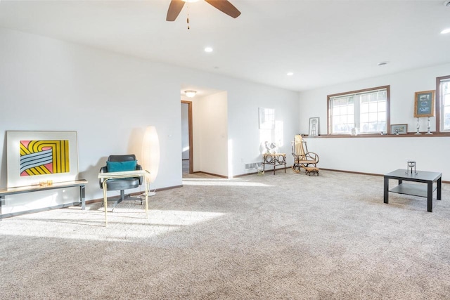 living area featuring light carpet and ceiling fan