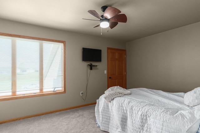 carpeted bedroom featuring multiple windows and ceiling fan