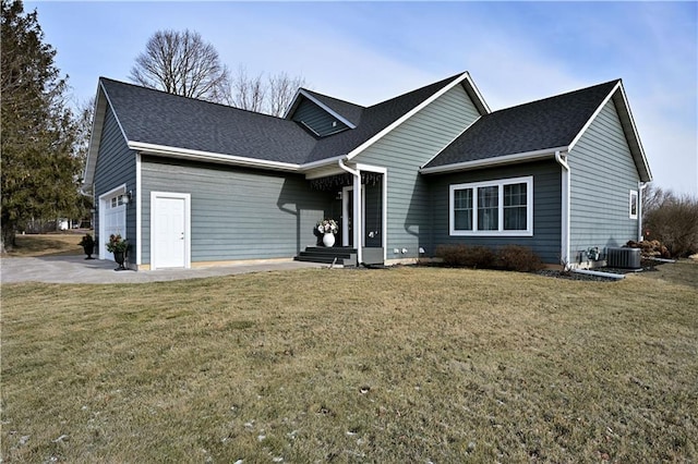 view of front facade with a front yard, central AC, and a garage