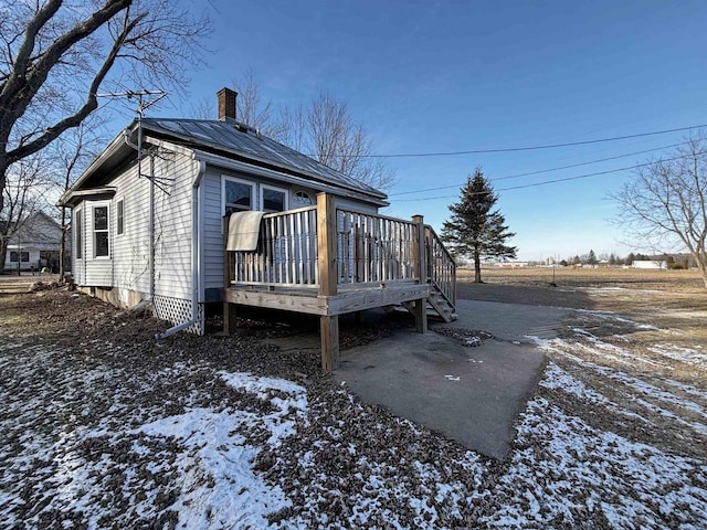 view of snowy exterior with a wooden deck