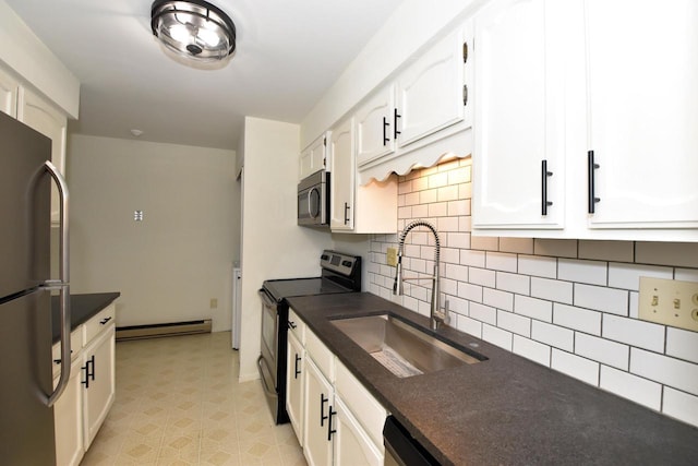 kitchen featuring decorative backsplash, stainless steel appliances, sink, a baseboard radiator, and white cabinetry