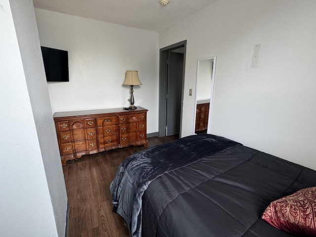 bedroom with dark hardwood / wood-style flooring