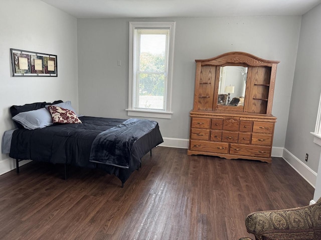 bedroom with dark hardwood / wood-style floors