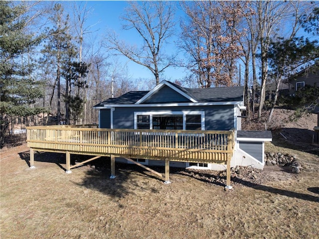 view of front facade with a wooden deck and a front lawn