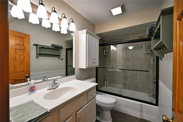 full bathroom with tile patterned floors, vanity, toilet, and enclosed tub / shower combo