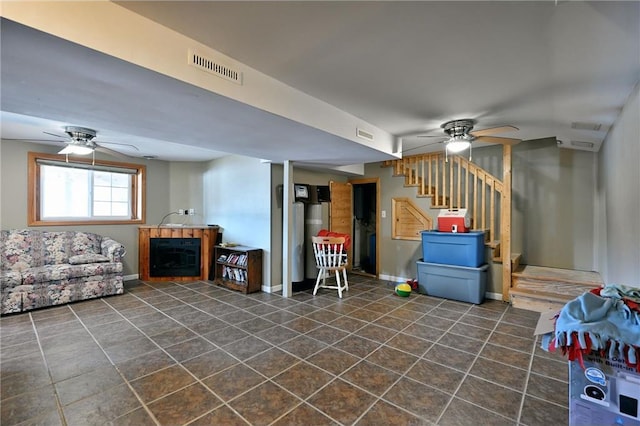 basement with ceiling fan and a fireplace