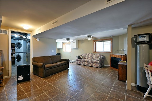 living room with ceiling fan and stacked washer and dryer