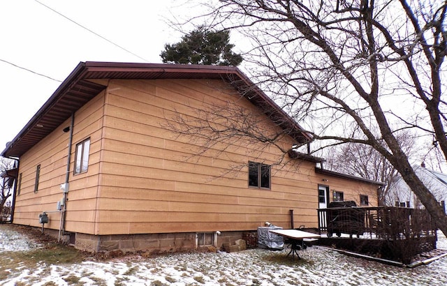 view of snowy exterior with a deck