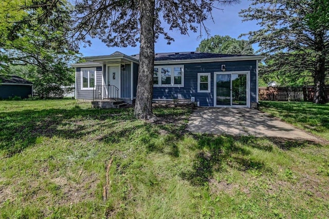 back of house featuring a lawn and a patio area