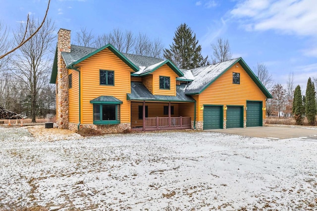 log-style house with a porch and a garage