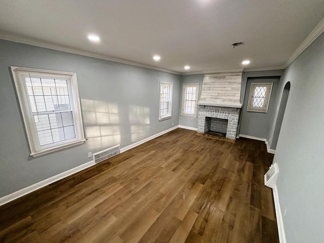 unfurnished living room with crown molding, a large fireplace, and dark hardwood / wood-style floors