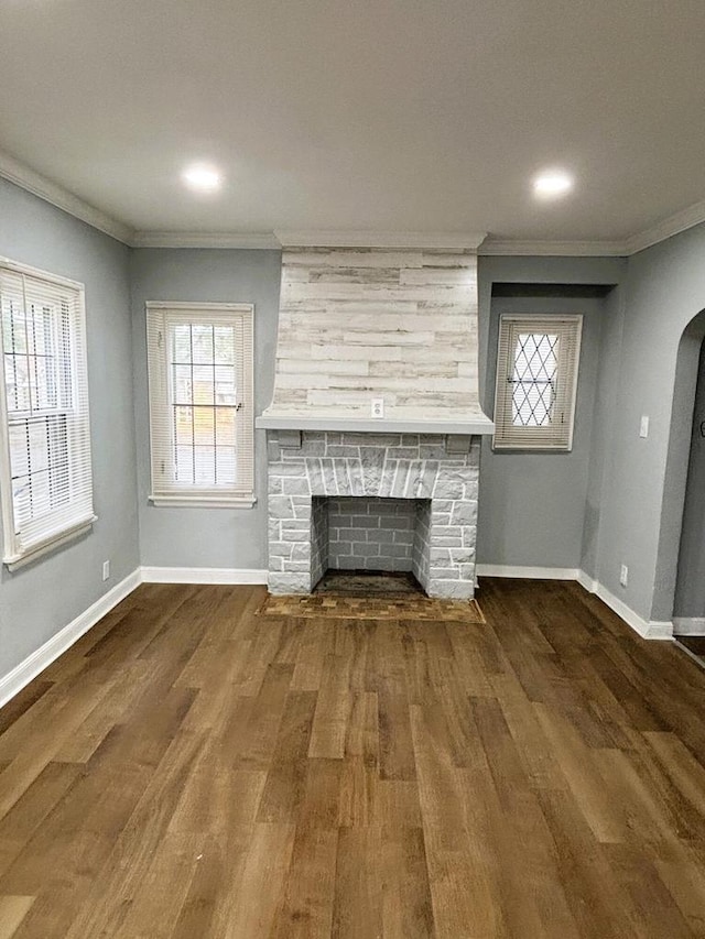 unfurnished living room with a fireplace, dark hardwood / wood-style floors, and crown molding