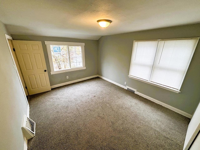 carpeted spare room featuring a textured ceiling