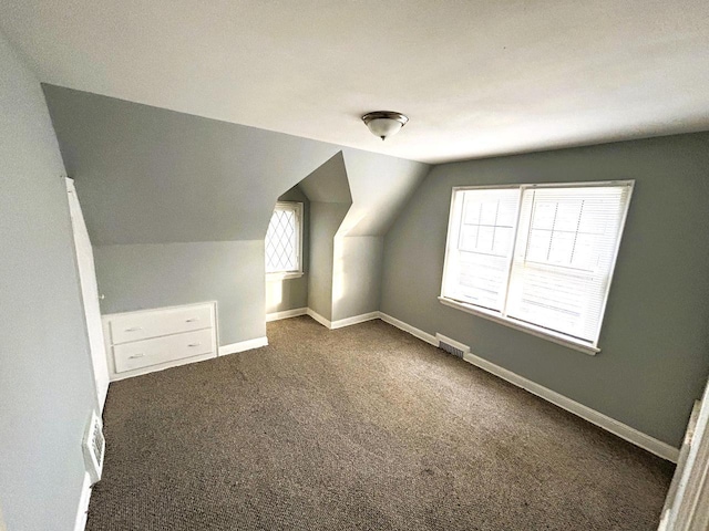 bonus room featuring dark carpet and vaulted ceiling