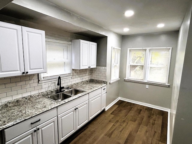 kitchen with tasteful backsplash, dark hardwood / wood-style flooring, sink, and white cabinets