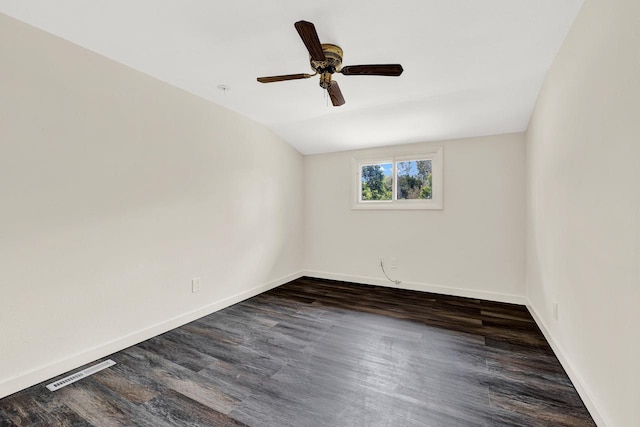 empty room with ceiling fan, dark hardwood / wood-style floors, and vaulted ceiling