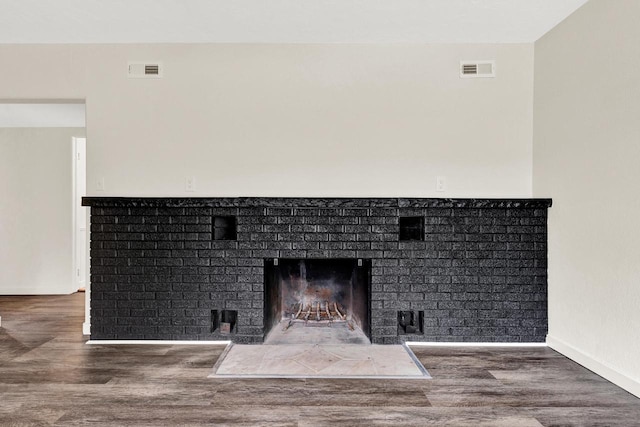 interior details featuring a fireplace and wood-type flooring