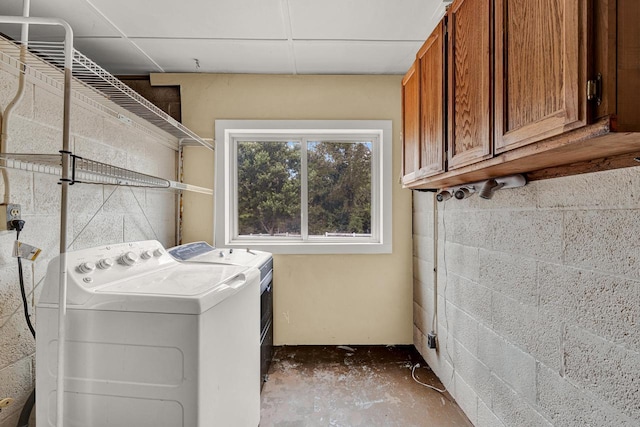 clothes washing area featuring washer and dryer and cabinets