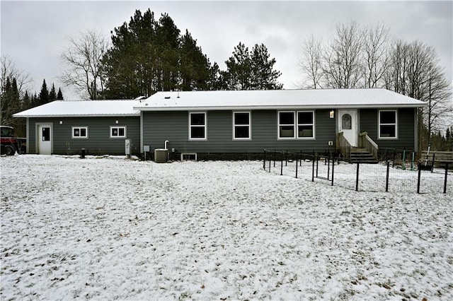 snow covered house featuring cooling unit