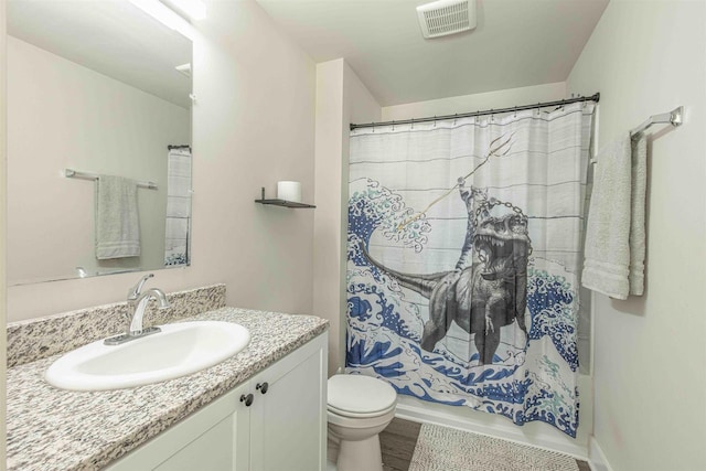 bathroom with hardwood / wood-style flooring, curtained shower, vanity, and toilet