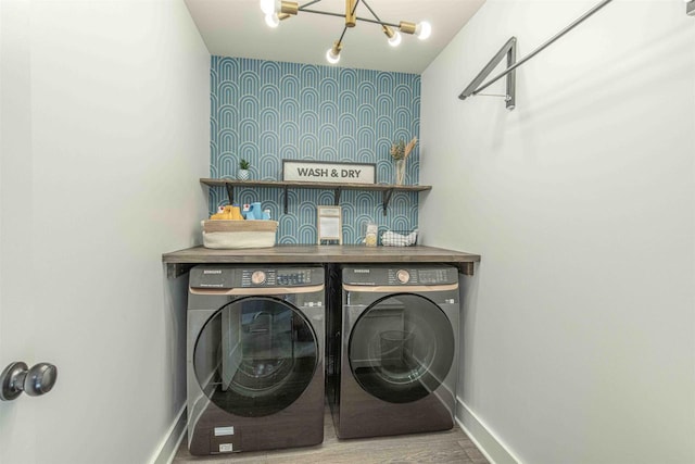 laundry area with washer and dryer and an inviting chandelier