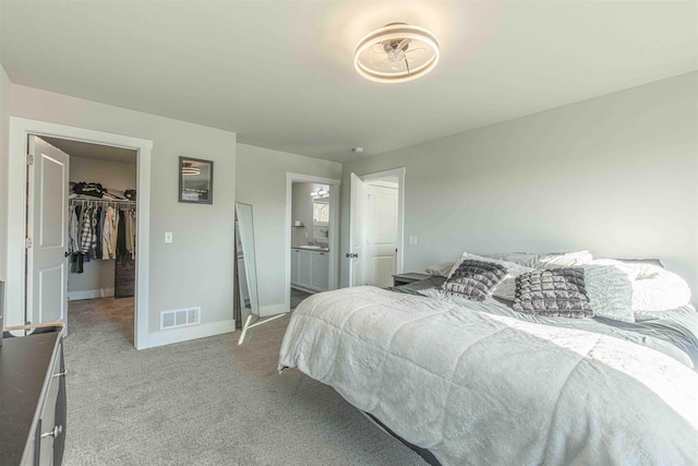 bedroom featuring ensuite bath, a spacious closet, a closet, and carpet floors