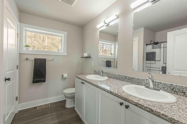 bathroom featuring toilet, vanity, and hardwood / wood-style flooring