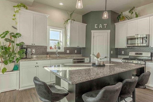 kitchen featuring sink, a kitchen island, white cabinets, and appliances with stainless steel finishes