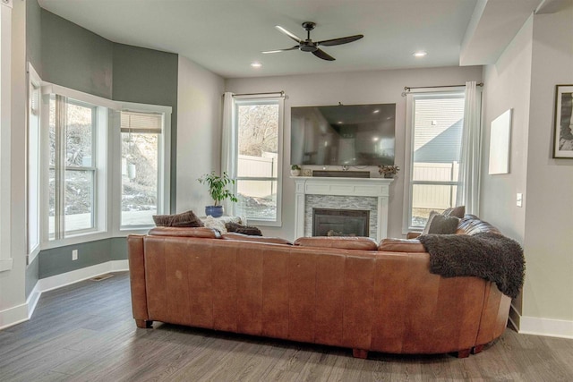 living room with ceiling fan, a fireplace, and hardwood / wood-style flooring