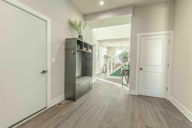 mudroom with a notable chandelier and wood-type flooring