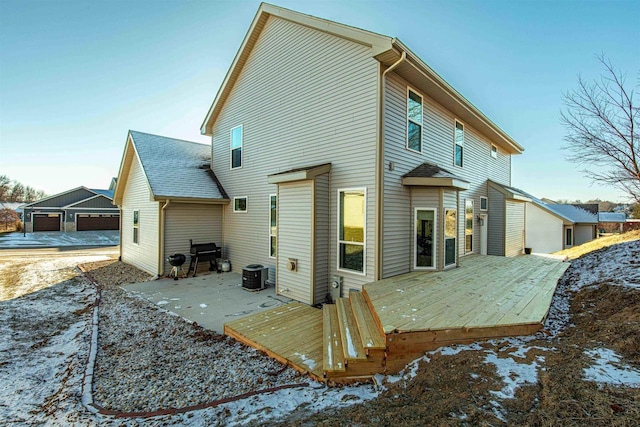 rear view of property featuring central AC unit and a wooden deck