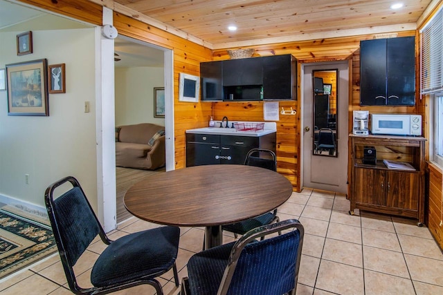 tiled dining area with wooden ceiling and wood walls