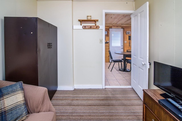 corridor featuring wood walls and light tile patterned floors