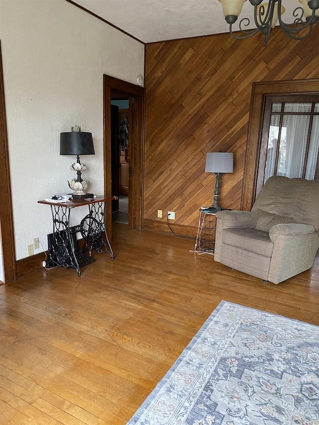 living room featuring a chandelier, wood-type flooring, and wood walls