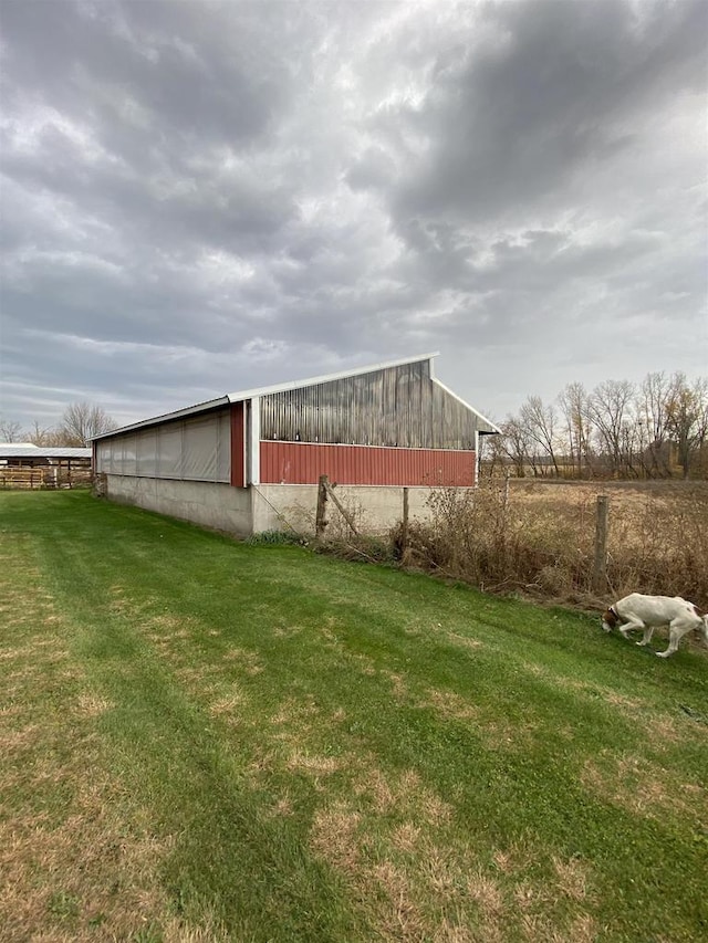 view of outdoor structure with a lawn and a rural view