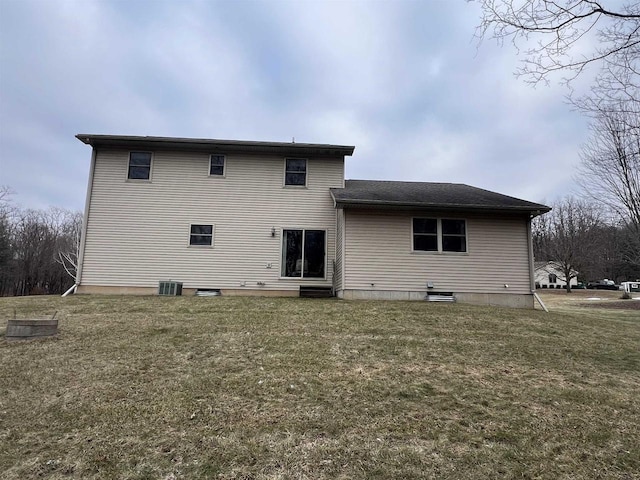 rear view of property featuring a yard and central AC