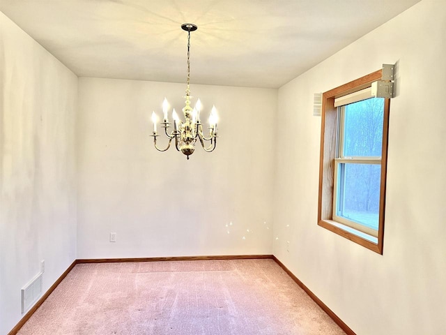 unfurnished room featuring a notable chandelier and carpet floors