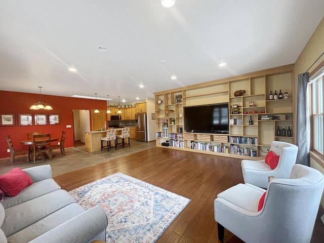 living room with light hardwood / wood-style floors and an inviting chandelier