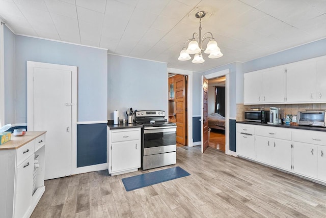 kitchen with tasteful backsplash, white cabinets, and stainless steel appliances