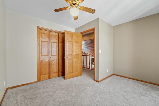 unfurnished bedroom with light carpet, a closet, and ceiling fan