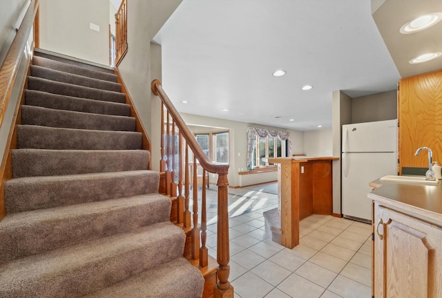 stairs with tile patterned flooring and sink