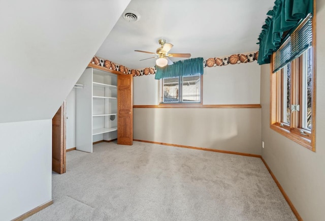 additional living space featuring ceiling fan, light colored carpet, and lofted ceiling