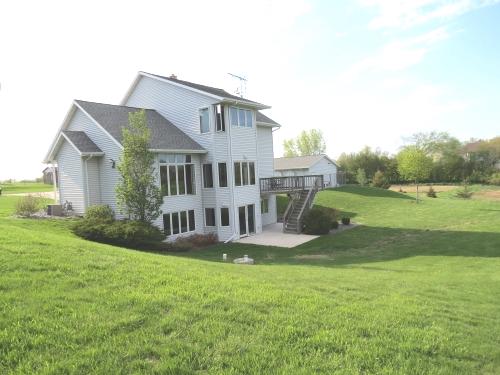 back of property featuring a lawn and a deck