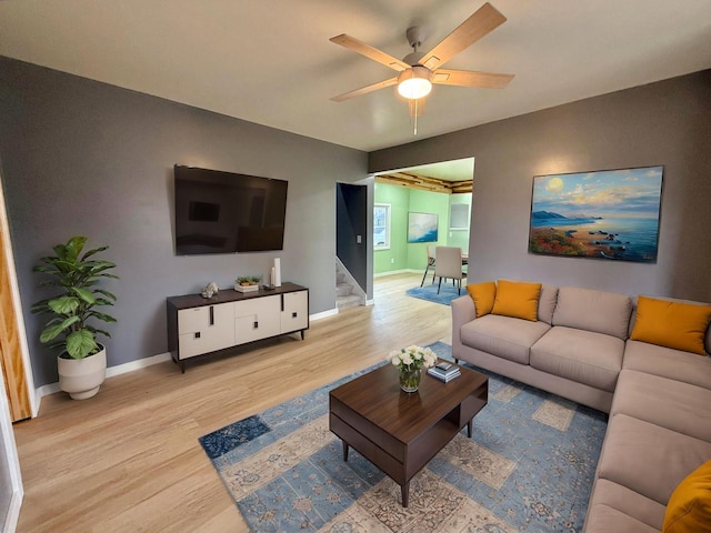 living room with light hardwood / wood-style flooring and ceiling fan