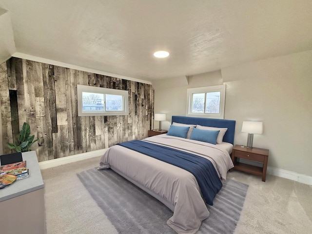 bedroom featuring light colored carpet and wooden walls