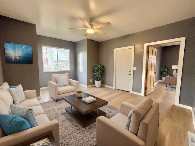 living room featuring ceiling fan and light hardwood / wood-style flooring