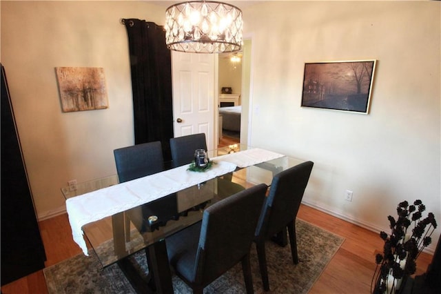 dining area with hardwood / wood-style flooring and an inviting chandelier