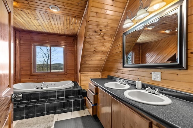 bathroom with tile patterned floors, wood ceiling, vanity, a relaxing tiled tub, and wood walls