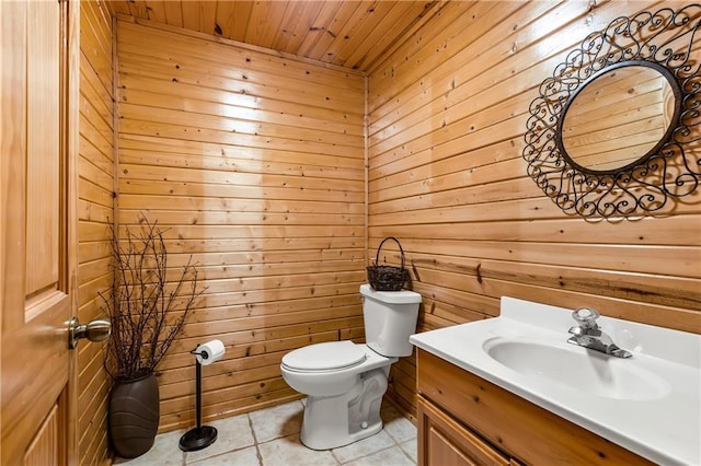 bathroom with vanity, toilet, wood ceiling, and wooden walls